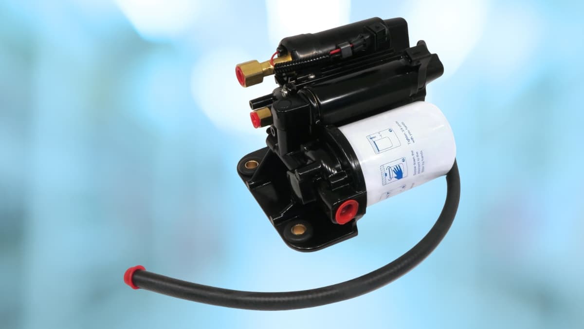 Black Volvo Penta fuel pump with attached filter and hose, shown against a soft blue background.
