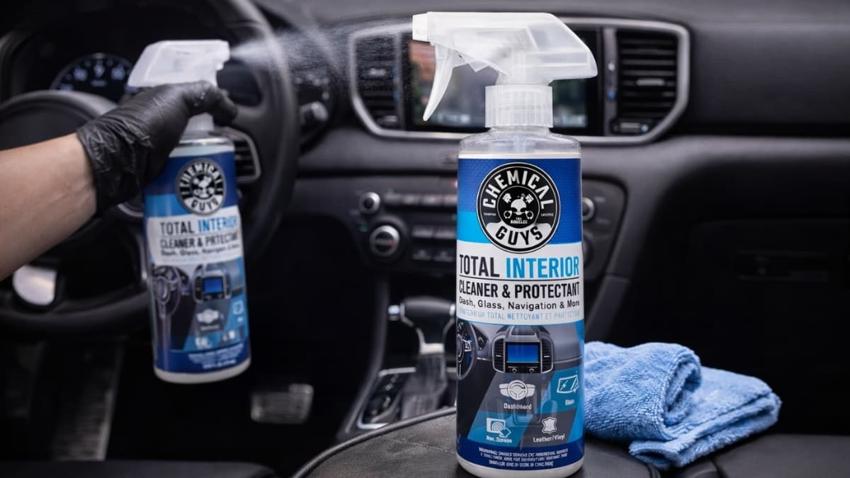 Chemical Guys Total Interior Cleaner & Protectant spray bottle on car dashboard with microfiber towel for interior detailing