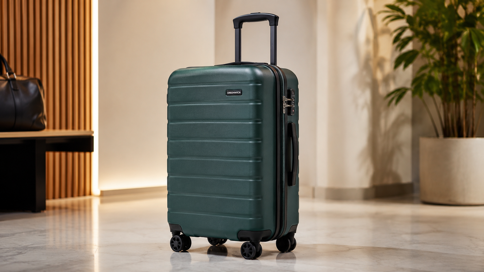 Greenwich DOHA 55cm cabin suitcase in dark green with a hard-shell ribbed design, spinner wheels, and telescopic handle, displayed in a modern indoor setting for carry-on travel.